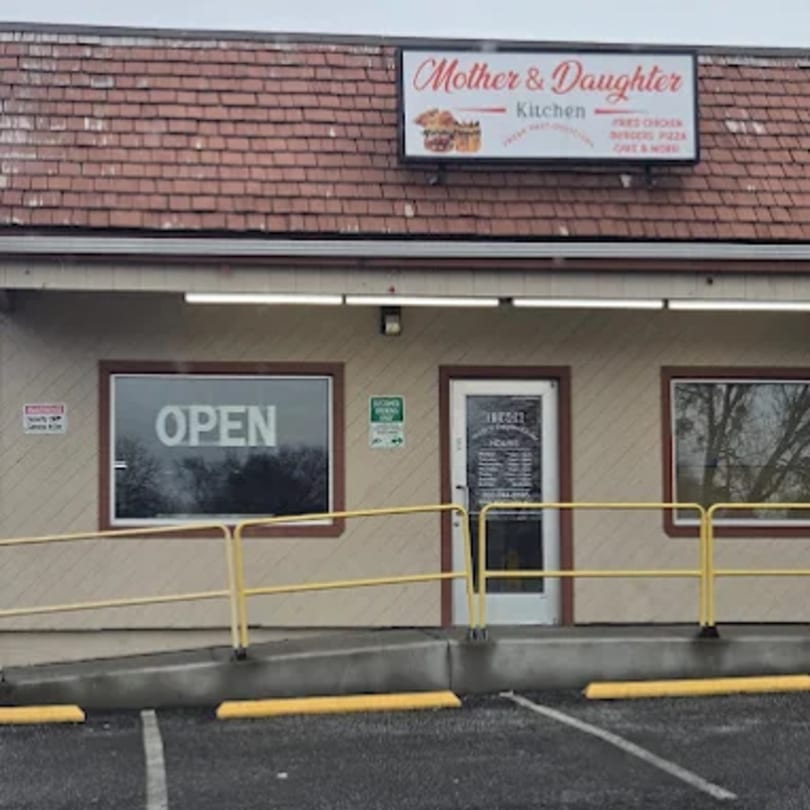 Exterior of Mother & Daughter Kitchen, a fast-food restaurant with a red shingle roof and "OPEN" sign.