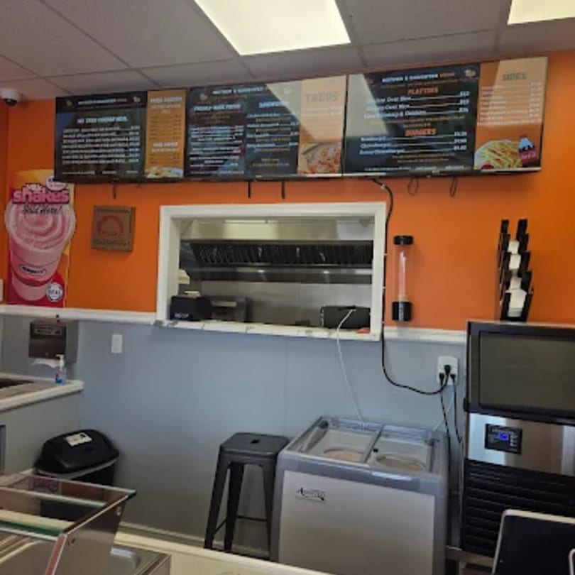 Mother & Daughter Kitchen's fast-food counter with menus, a service window, and kitchen equipment.