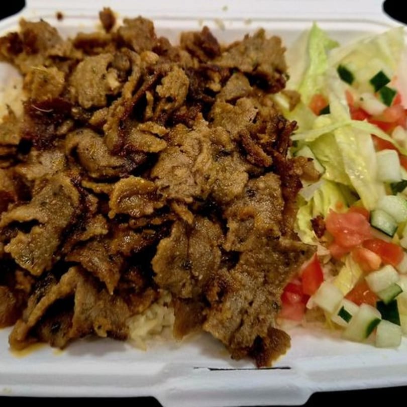 Mother & Daughter Kitchen's fast-food gyro meat with rice and a side salad in a takeout container.