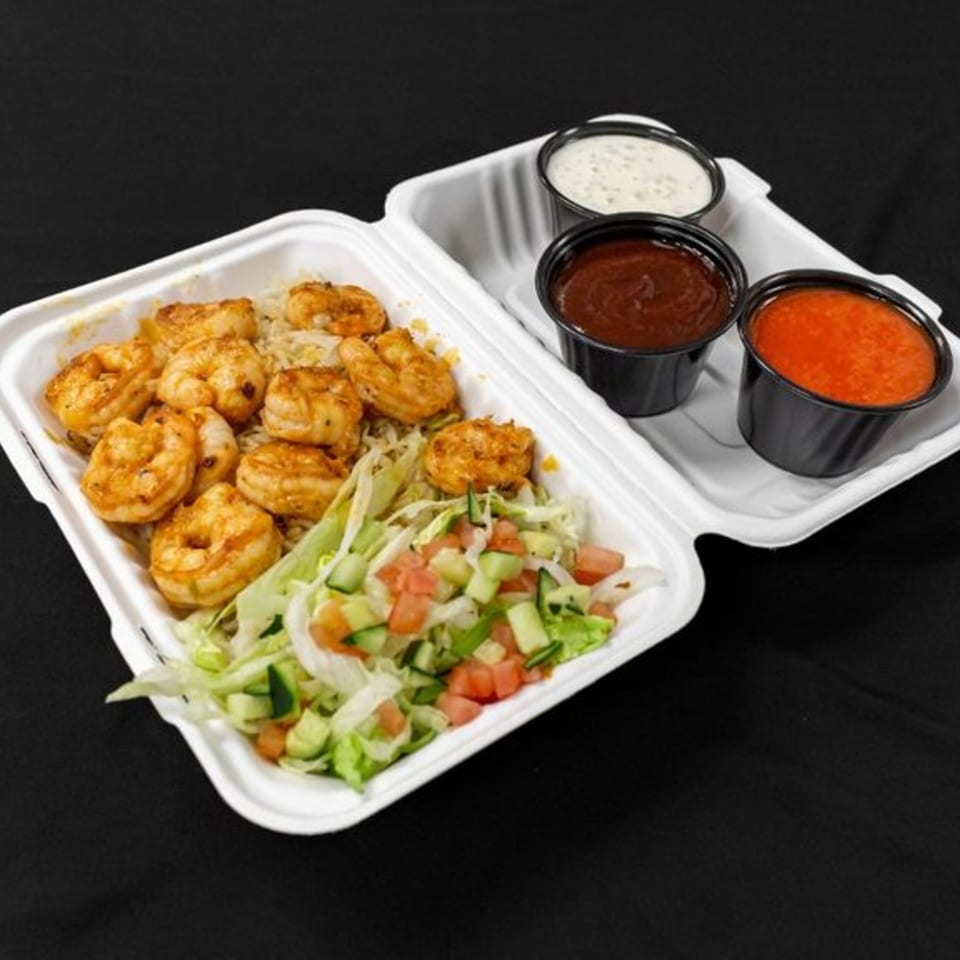 Mother & Daughter Kitchen's shrimp platter with rice, salad, and three dipping sauces in a takeout container.